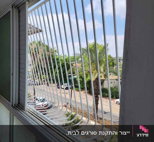 סורג ברזל לבן עם בטן מותקן בחלון דירה